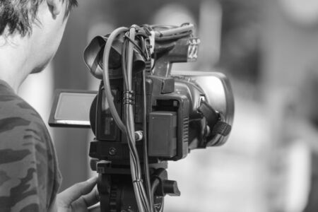 black and white tone professional cameraman - covering an event to a live and record video at...
