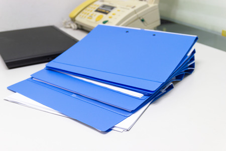 file folder with documents and Notebook background  on white table in work office, business concept.の写真素材