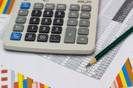 business paper graphs and pen with charts report, calculator on desk of financial planning, concepts business and cost.の写真素材