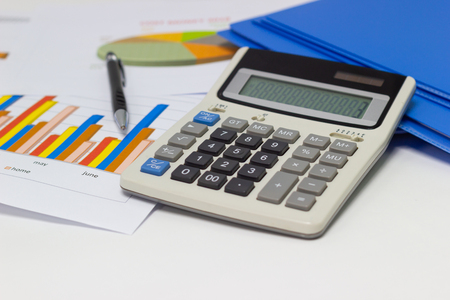 business paper graphs and pen with charts report, calculator on desk of financial planning, concepts business and cost.の写真素材