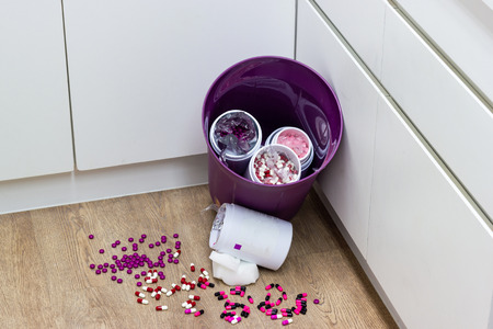 Multi colored pills expire, dropped into the trash. Health conceptの写真素材