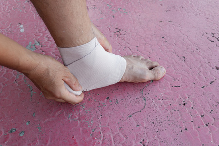Male athlete applying Stretch fabric Stretch fabric wrapped around your legs of a football player, Sports injuries.の写真素材