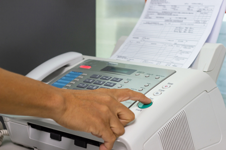 hand man are using a fax machine in the office. Business conceptの写真素材