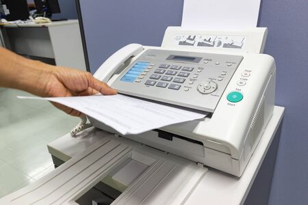 hand man are using a fax machine in the office Business conceptの写真素材