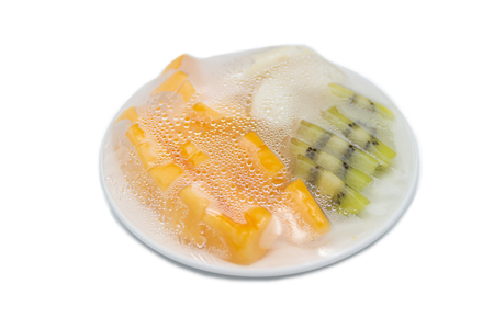 fruits which are wrapped with plastic film preservation on a table on white background.の写真素材