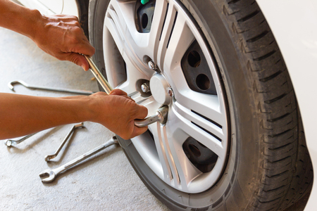 Car mechanician changing tire car wheel in auto repair shopの写真素材
