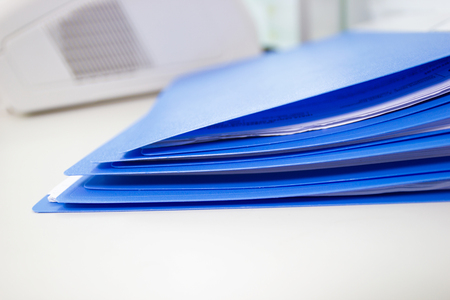 Blue files folder and paper on white table in office, concept Office suppliesの写真素材