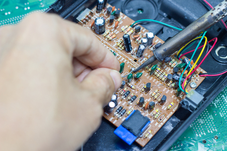 Technician repairing electronic of the computer circuit board by soldering Irons, concept  technology of computer circuit hardwareの写真素材