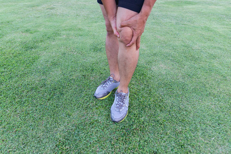 Tendon knee joint problems on Man's leg from exercise In the stadium.の写真素材
