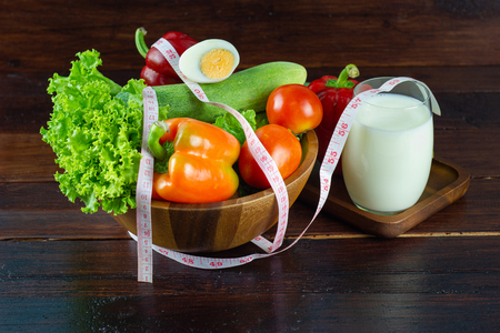 A green salad in wood cup consisting of a mixture of small usually Green leafy vegetable, Various kinds of vegetables with milk in a glass concept good for health Weight controlの写真素材