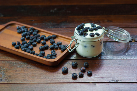 Closeup Detail fresh Blueberries with yogurt in glass on wooden tablesの写真素材