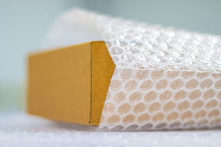 Bubbles covering the box by plastic wrap for protection product cracked  or insurance During transit -isolated white backgroundの写真素材