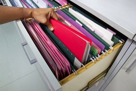 Hand of Man Search files document in a file cabinet in work office, concept business office life.