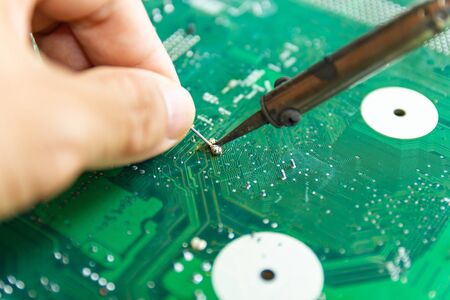 Technicians are using a soldering iron for repairing electronic of the computer circuit board concept technology of computer circuit hardware.の写真素材
