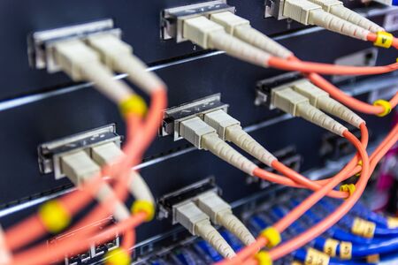 cable network , fiber optic cable connect to switch port in server room , Concept network managementの写真素材