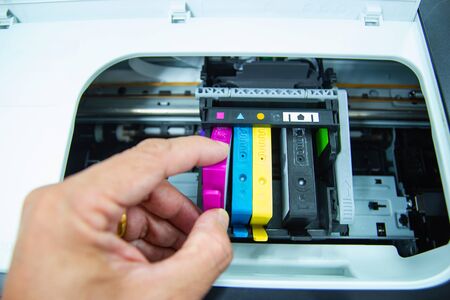 Technicians are install setup the ink cartridge of a inkjet printer the device of office automate...