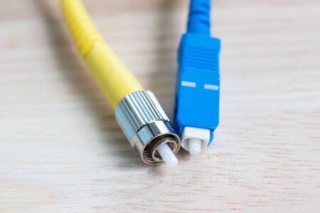 close-up single cable fiber optical connector ST-type on wood tableの写真素材