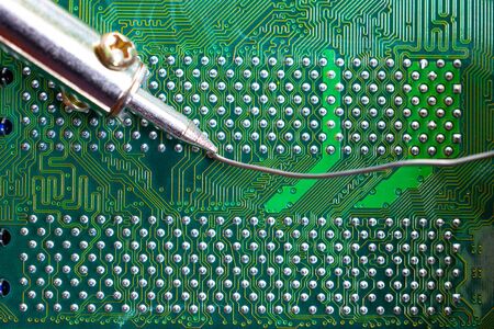 soldering iron for repairing electronic of the computer circuit board concept technology of computer...
