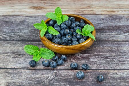 Fresh blueberries with mint leaves on wood table の写真素材
