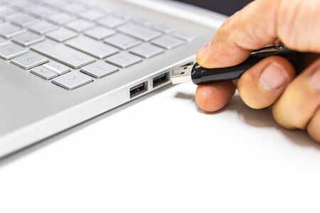 hand man hold Flash drive connect to USB port plug-in computer laptop for transfer data and backup...