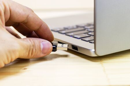 hand man hold Flash drive connect to USB port plug-in computer laptop for transfer data and backup...