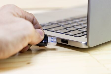 hand man hold Flash drive connect to USB port plug-in computer laptop for transfer data and backup business concept の写真素材