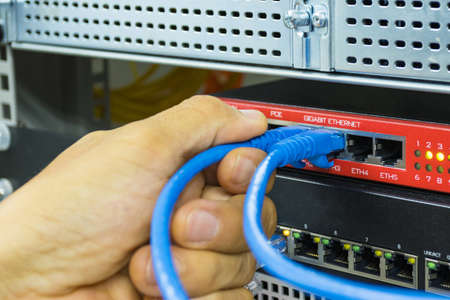 Hand of man holding The network cables to connect Lan port, concept Communication connection...