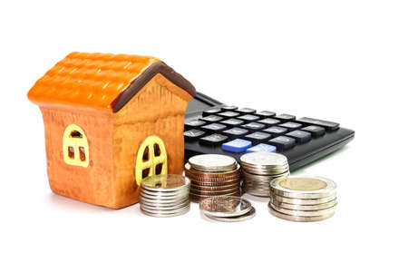 Model house with coin, calculator concept Collecting money Buying a house, residence, business financeの写真素材