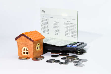Model house with coin, calculator, book bank, concept Collecting money Buying a house, residence, business, financeの写真素材