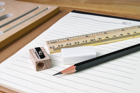 pencil, eraser,ruler with book on woodtableの写真素材