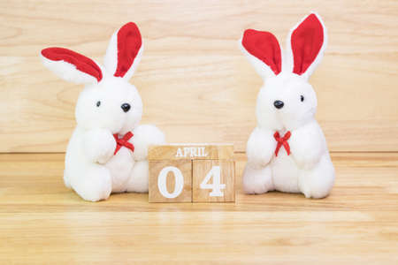 White rabbit doll with wood text April 4 on wood tableの写真素材