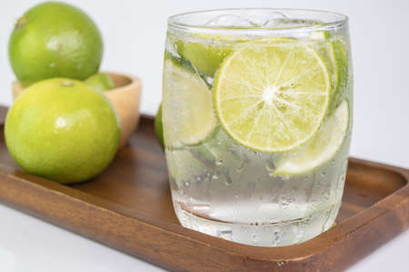 Cold Drink from Lemon cut into pieces in water glass on wood cupの写真素材