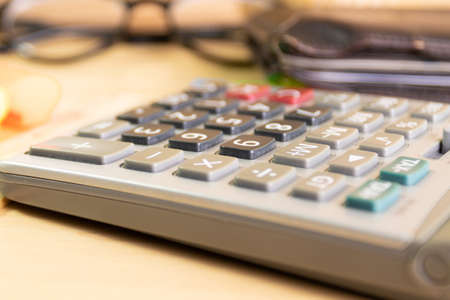 close up calculator equipment for income, expenditure, calculation on wood tableの写真素材