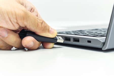 Hand of Businessman push the USB Drive to USB Port for Laptop transfer data or save data