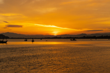 Sunset at the lake with fishing boat in the foreground, Thailandの写真素材