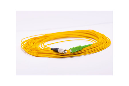 Yellow fiber optic cable rolled on white background, long network cable for data and internet...