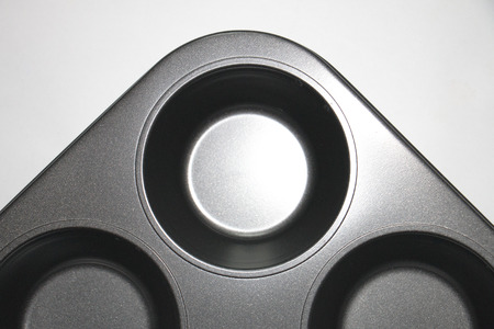 Gray cupcake tray. Metal bake tray for muffins isolated on white.の写真素材