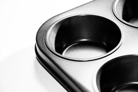 Gray cupcake tray. Metal bake tray for muffins isolated on white.の写真素材