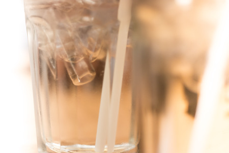 Straw and glass with ice and waterの写真素材