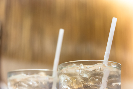 straw and glass with ice and waterの写真素材