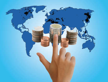 hand touching coins on world map