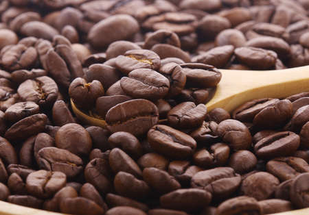 Coffee beans on wooden spoonの写真素材