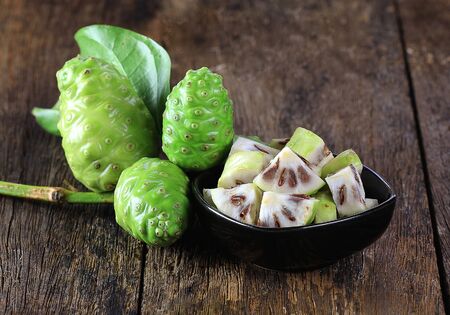 Noni fruit sliced on wooden boardsの写真素材