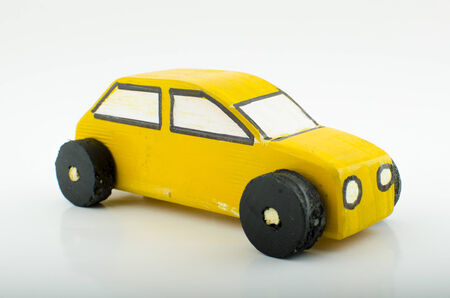 Single yellow wooden toy car with a white background.の写真素材