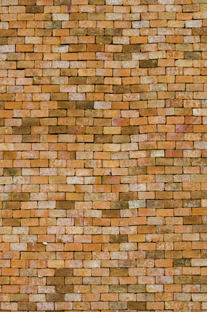 Weathered texture of stained old dark brown and red brick wall background, grungy rusty blocks of stone-work technology, colorful horizontal architectureの写真素材