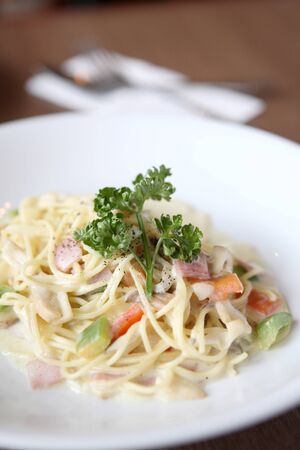 Spaghetti with mushroom and ham white sauce on wood backgroundの写真素材