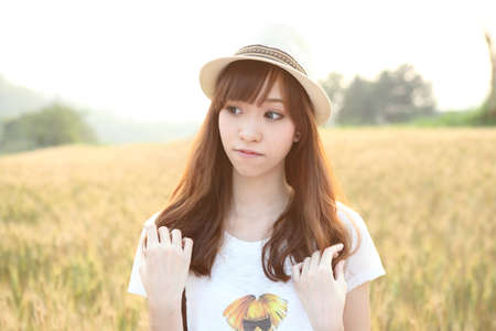 Young smiling woman in field with wheatのeditorial素材
