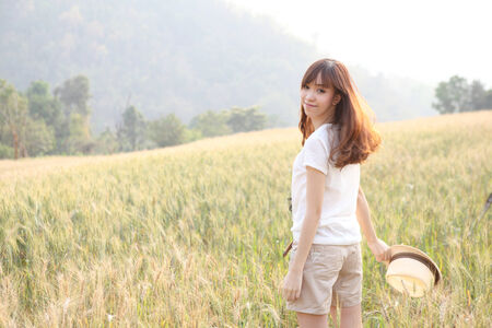 Young smiling woman in field with wheatのeditorial素材
