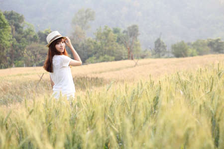 Young smiling woman in field with wheatのeditorial素材