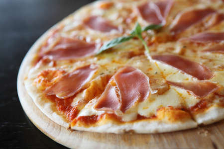 Pizza with dry cured ham and basilの写真素材